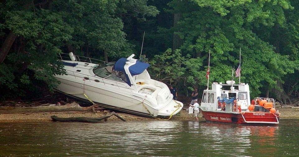 Is this a towing job or a salvage job? Boats that are hard aground like this cruiser are most likely to be declared salvage, which is not typically covered by a towing service plan, says BoatUS.