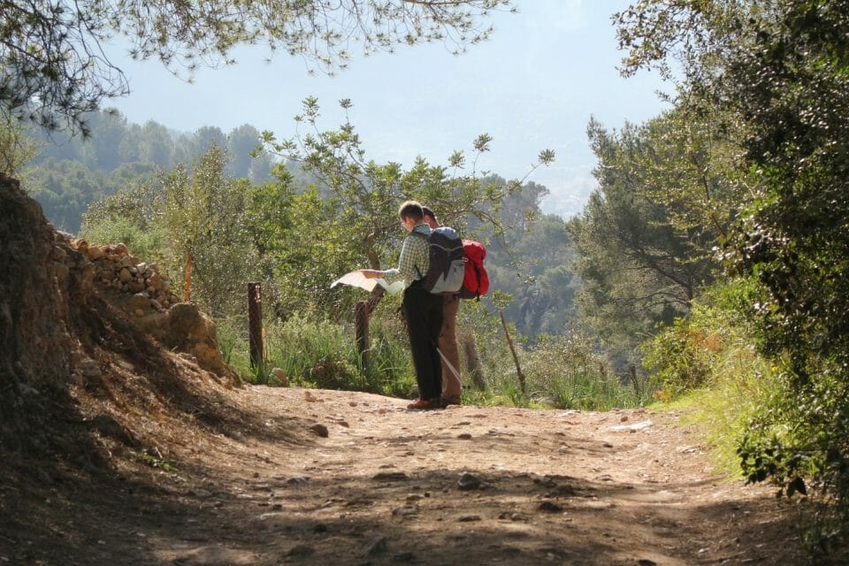 A person riding a bike down a dirt road

Description automatically generated