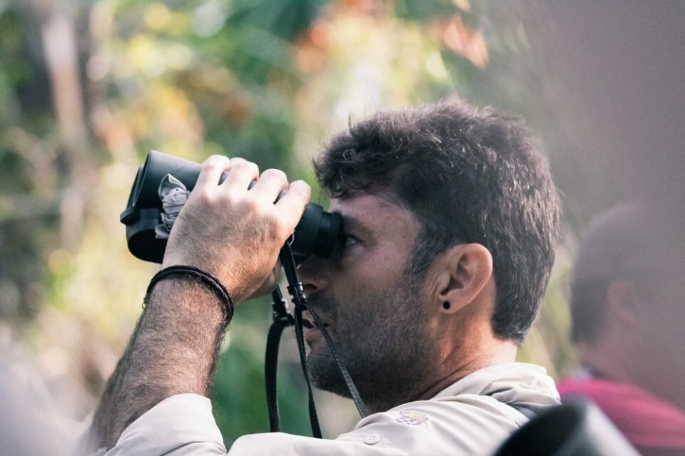 man using black binoculars at daytime